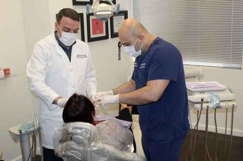 Dr. Kanaan and Dr. Samo conducting a joint patient consultation in a dental office.
