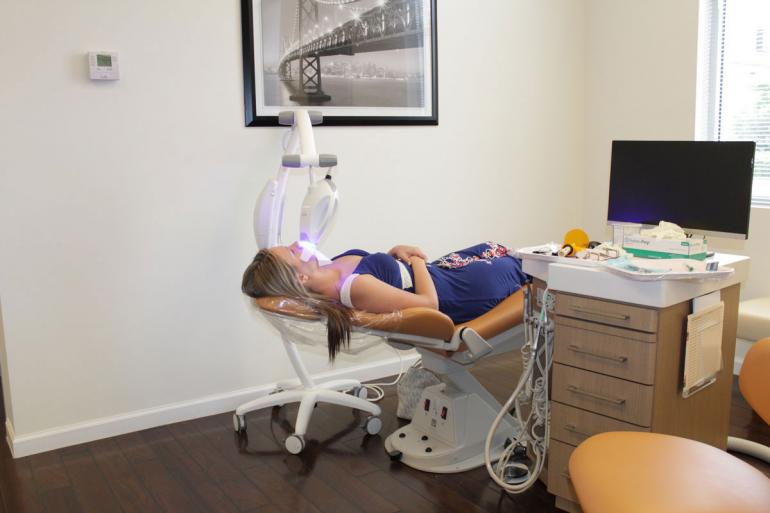 A relaxed patient whitening her teeth